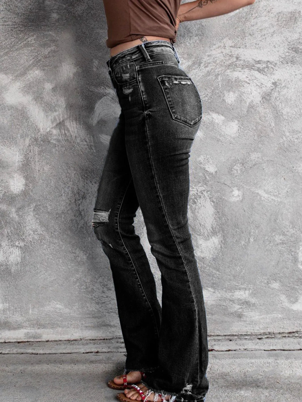 Utsvängda jeans med knappstängning och slitna detaljer – bild 10