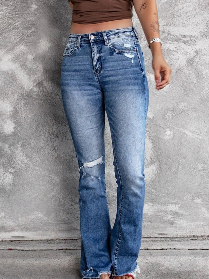 Utsvängda jeans med knappstängning och slitna detaljer
