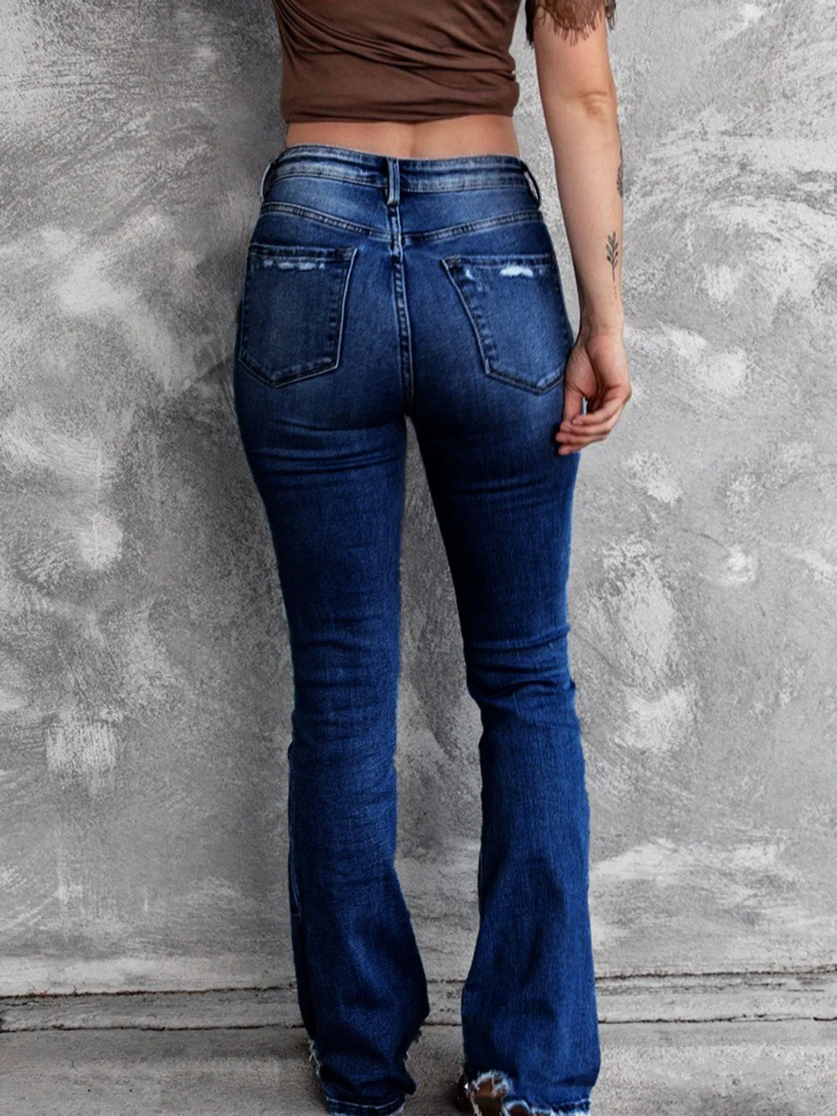 Utsvängda jeans med knappstängning och slitna detaljer – bild 8