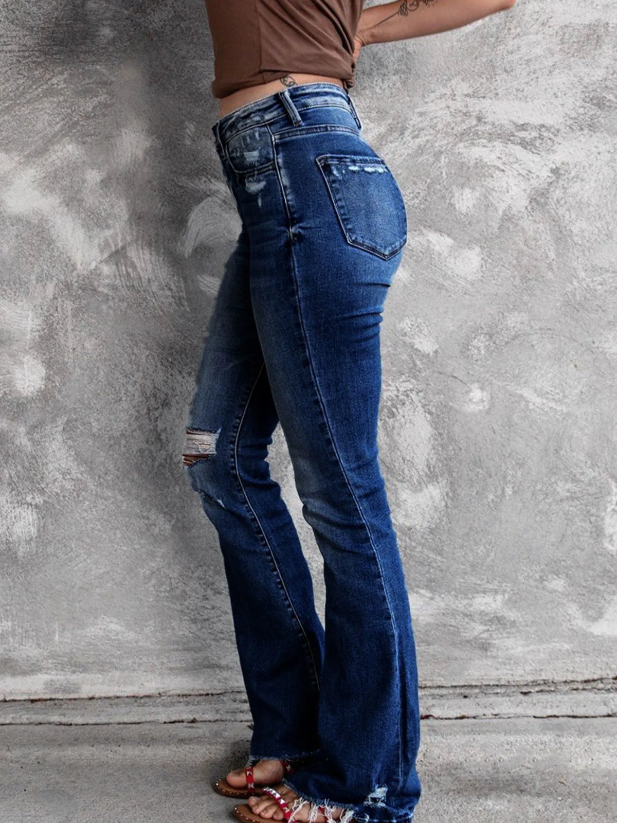 Utsvängda jeans med knappstängning och slitna detaljer – bild 7
