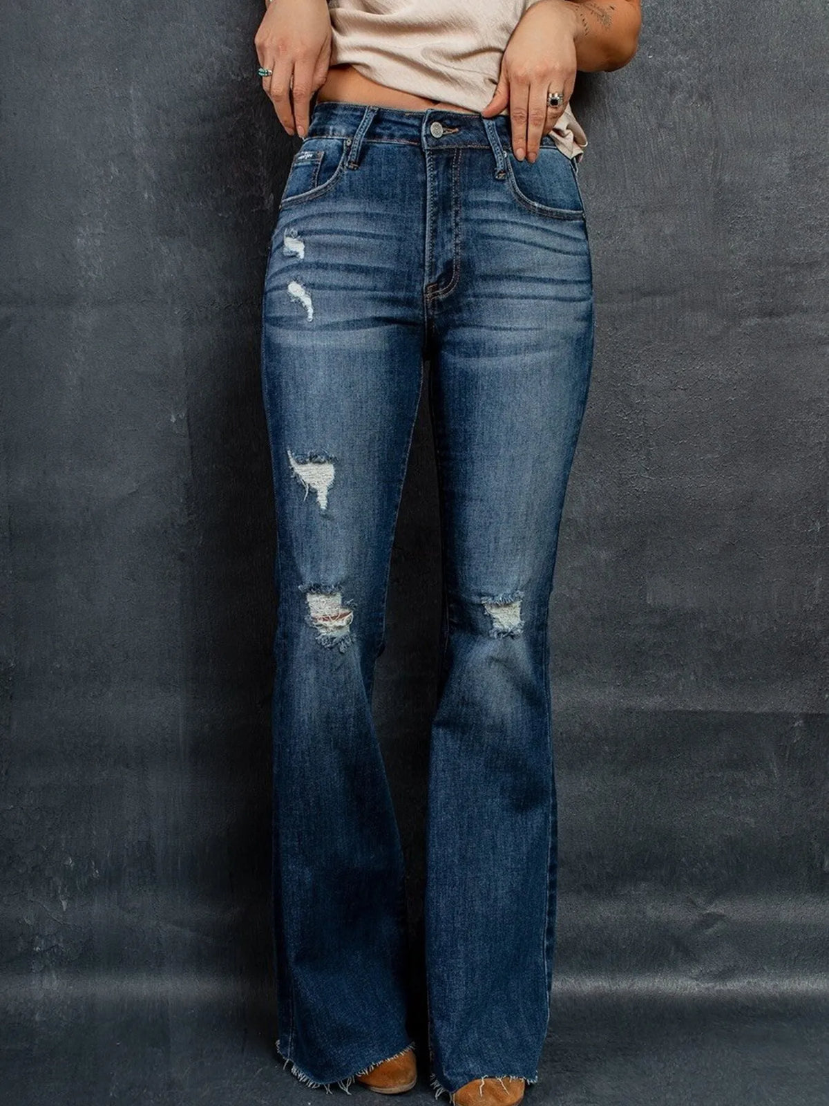Utsvängda jeans med revor vid knäna