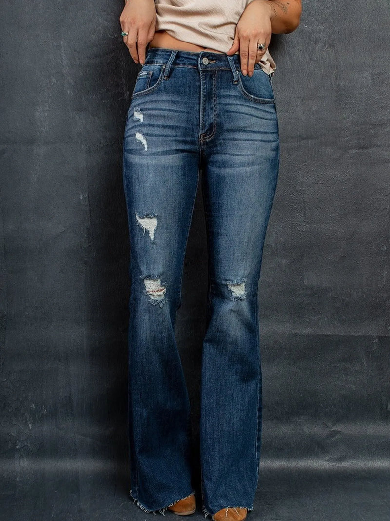 Utsvängda jeans med revor vid knäna