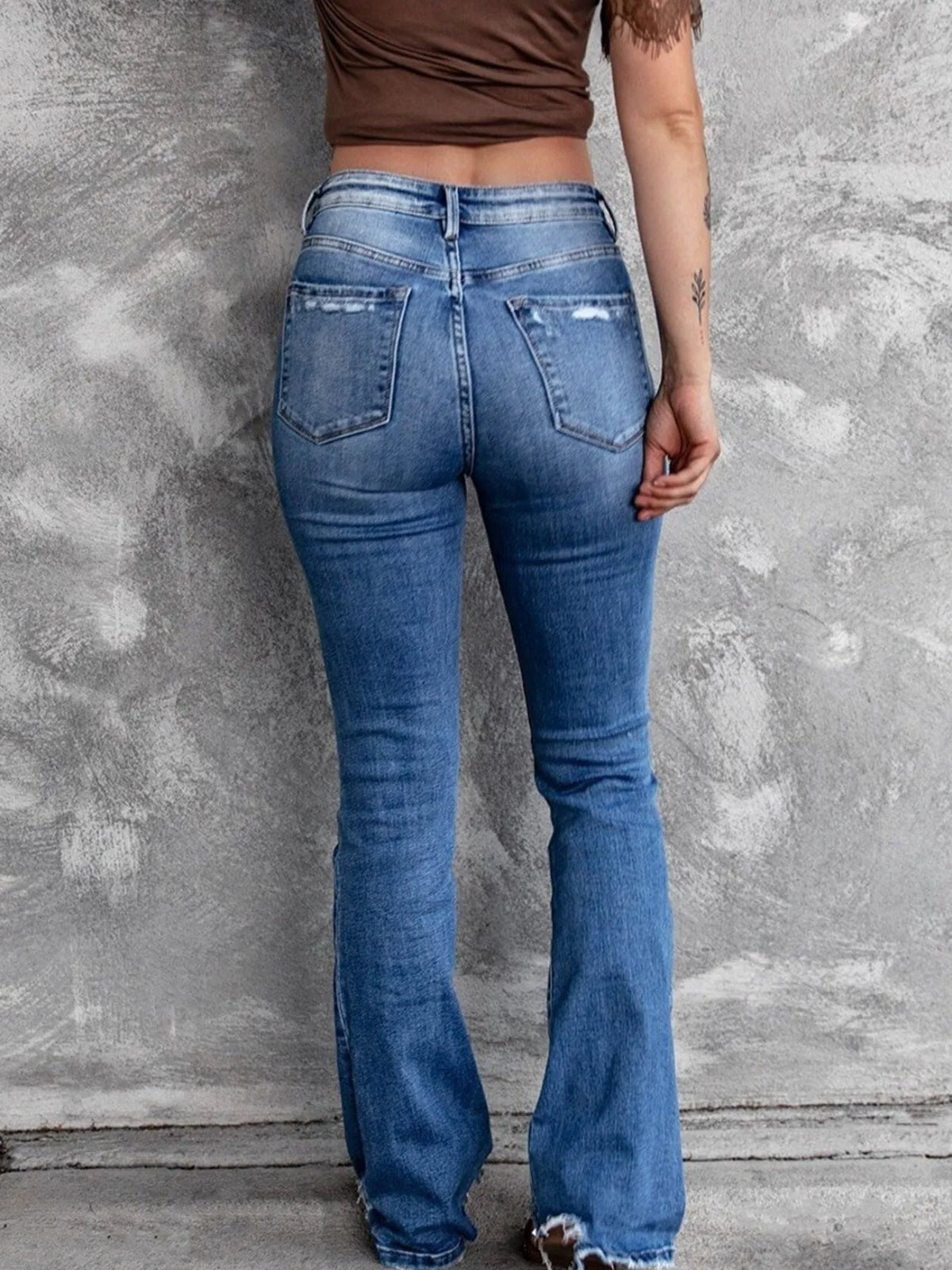 Utsvängda jeans med knappstängning och slitna detaljer – bild 4
