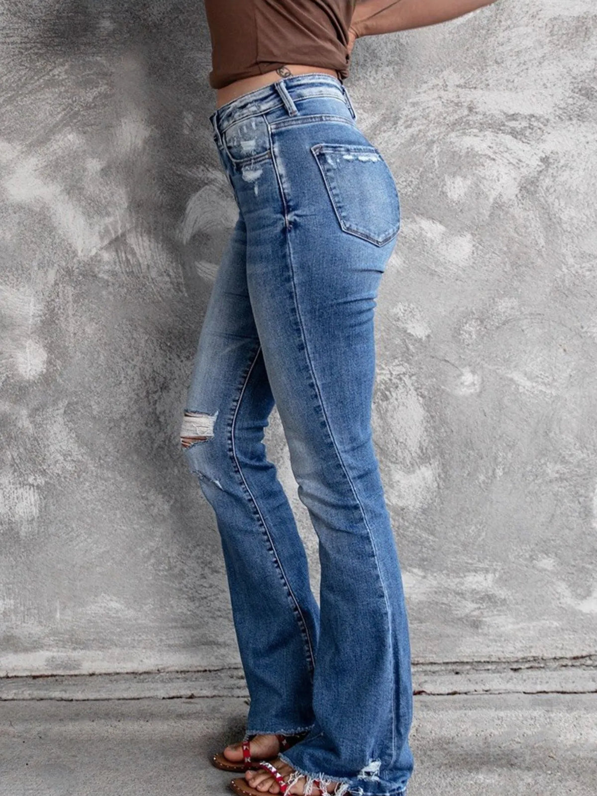 Utsvängda jeans med knappstängning och slitna detaljer – bild 3