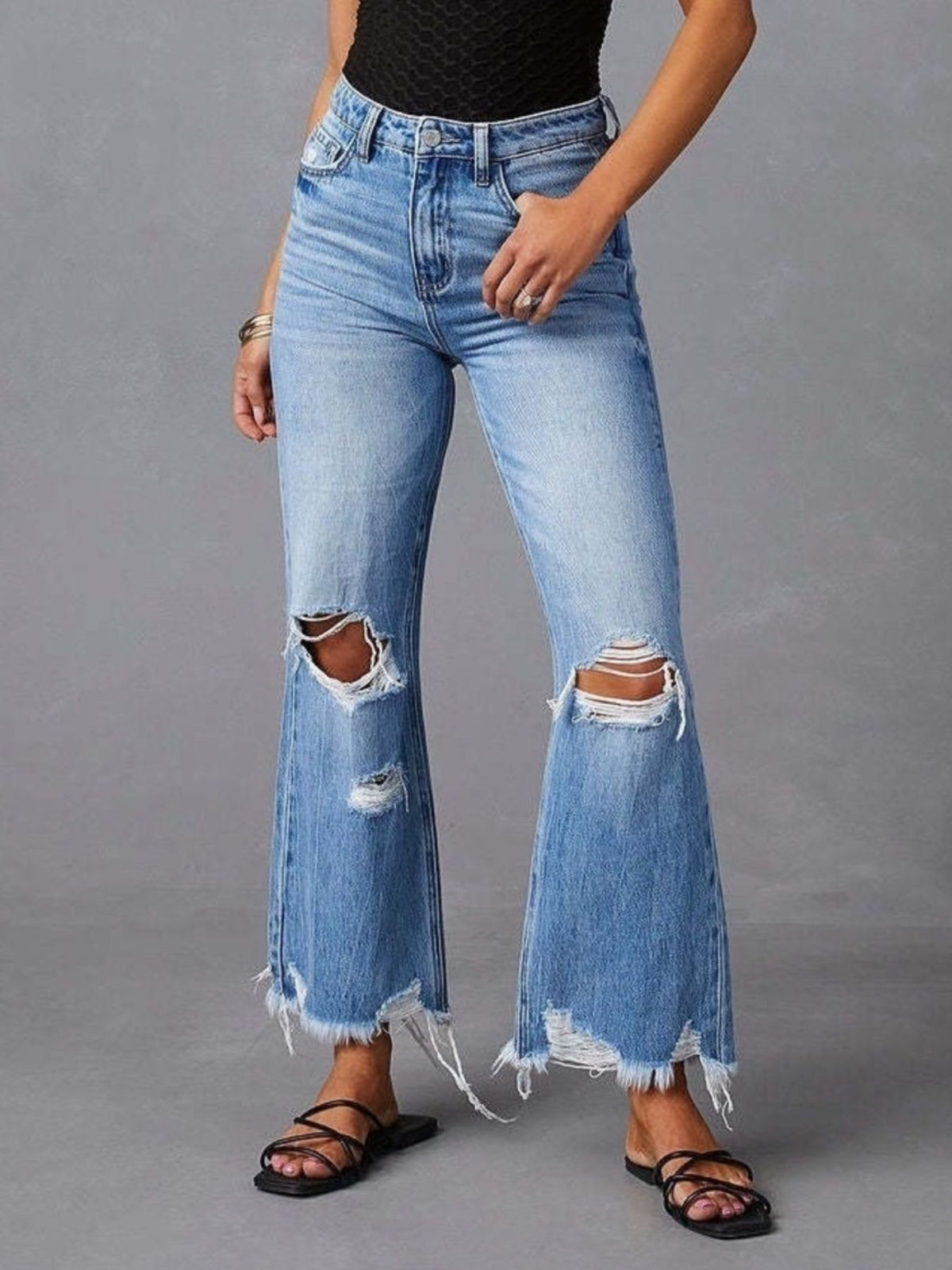 Utsvängda jeans med rå kant och slitna detaljer
